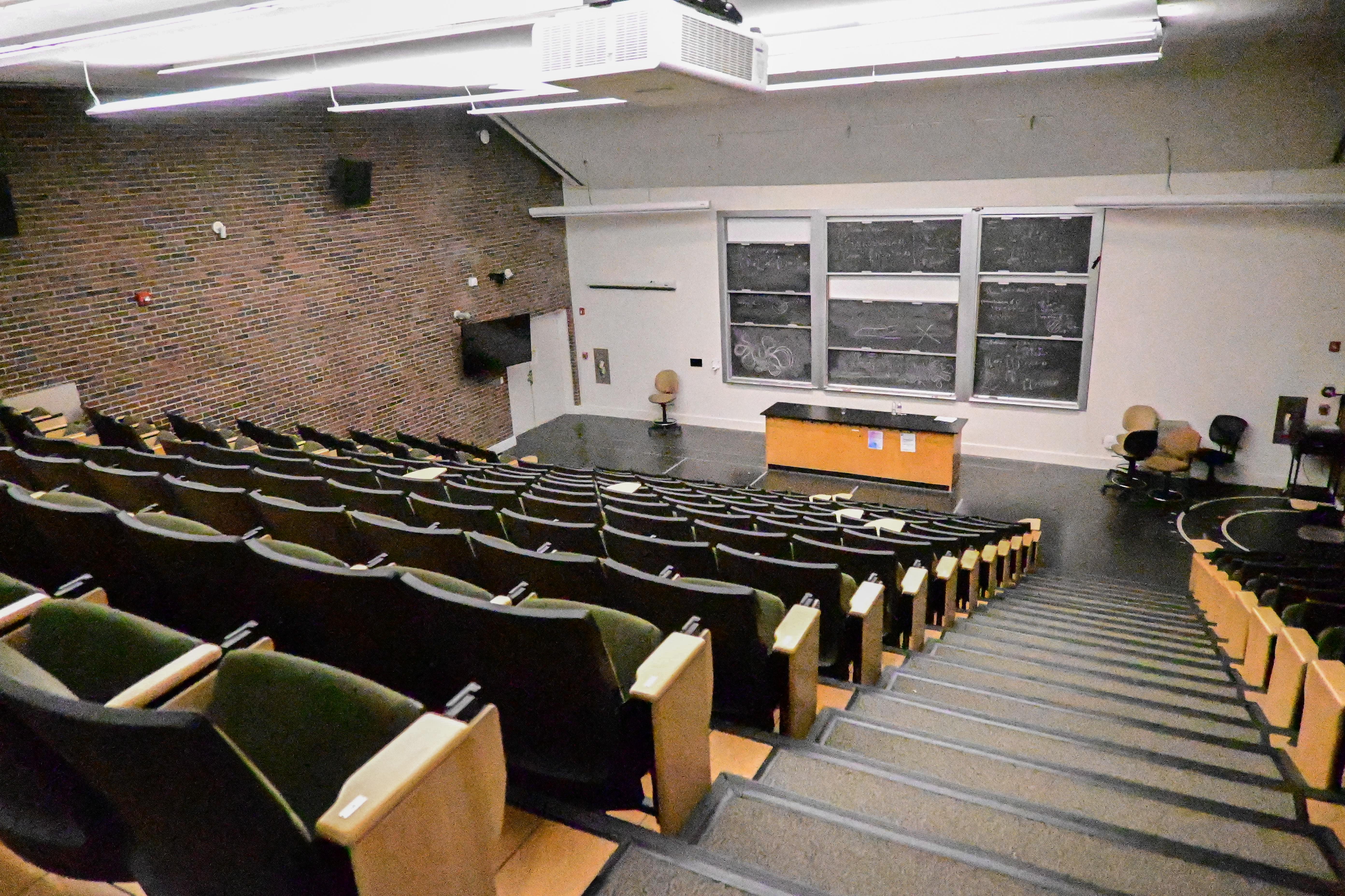 Photo of empty lecture hall in Barus and Holley 166, with some chalk left on the blackboards.