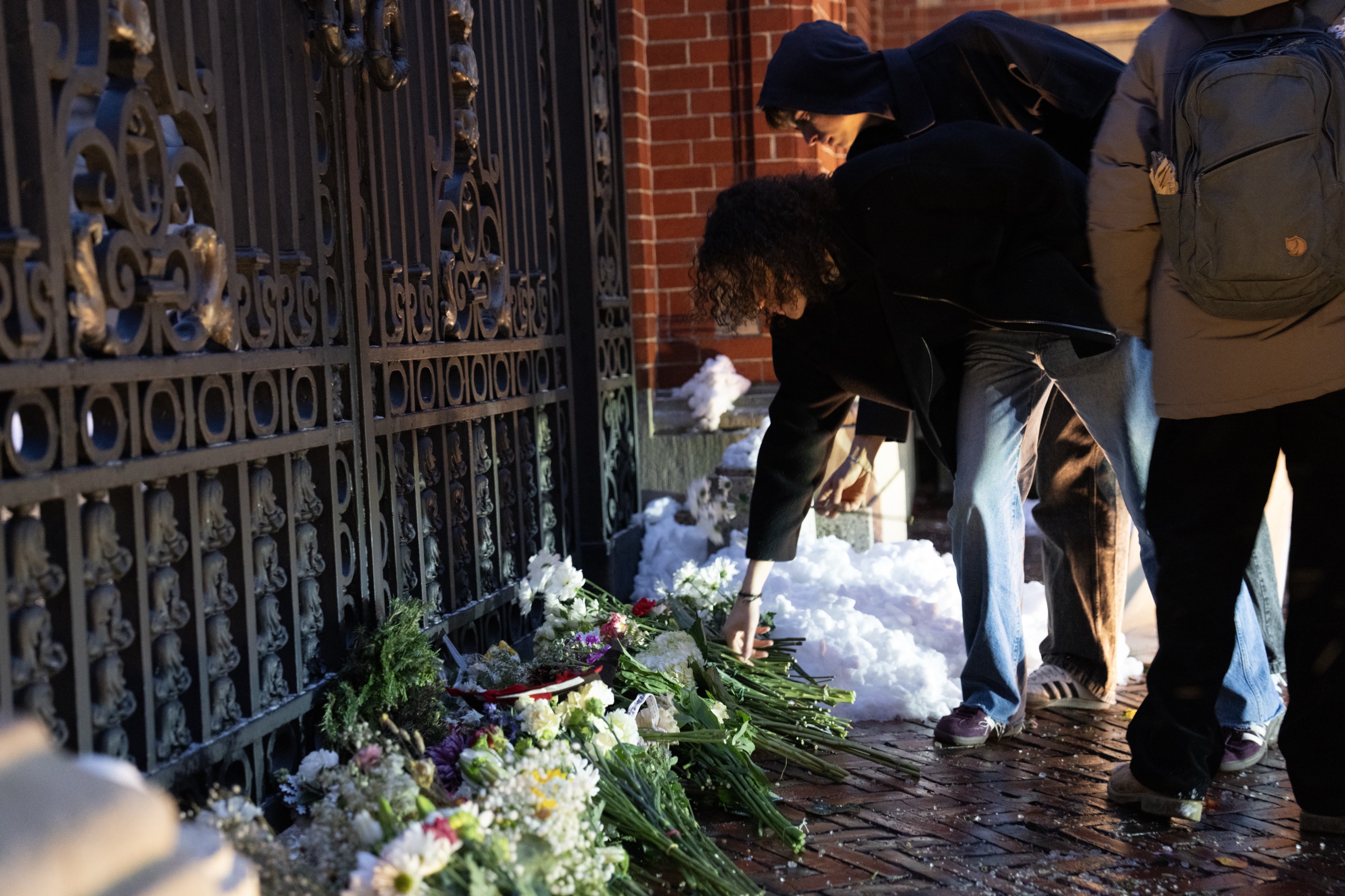 Students lay flowers at the Van Wickle gates