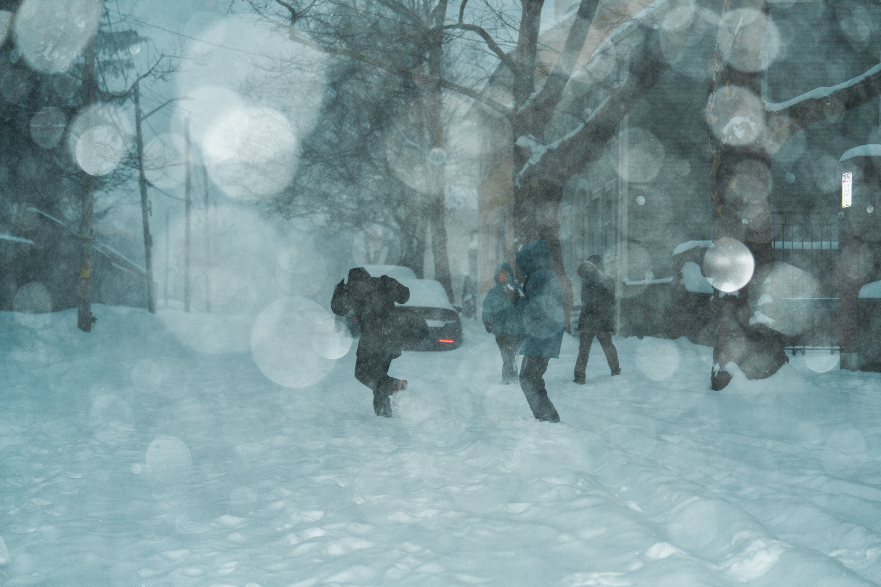 Photo of three students running in a road coated in snow.