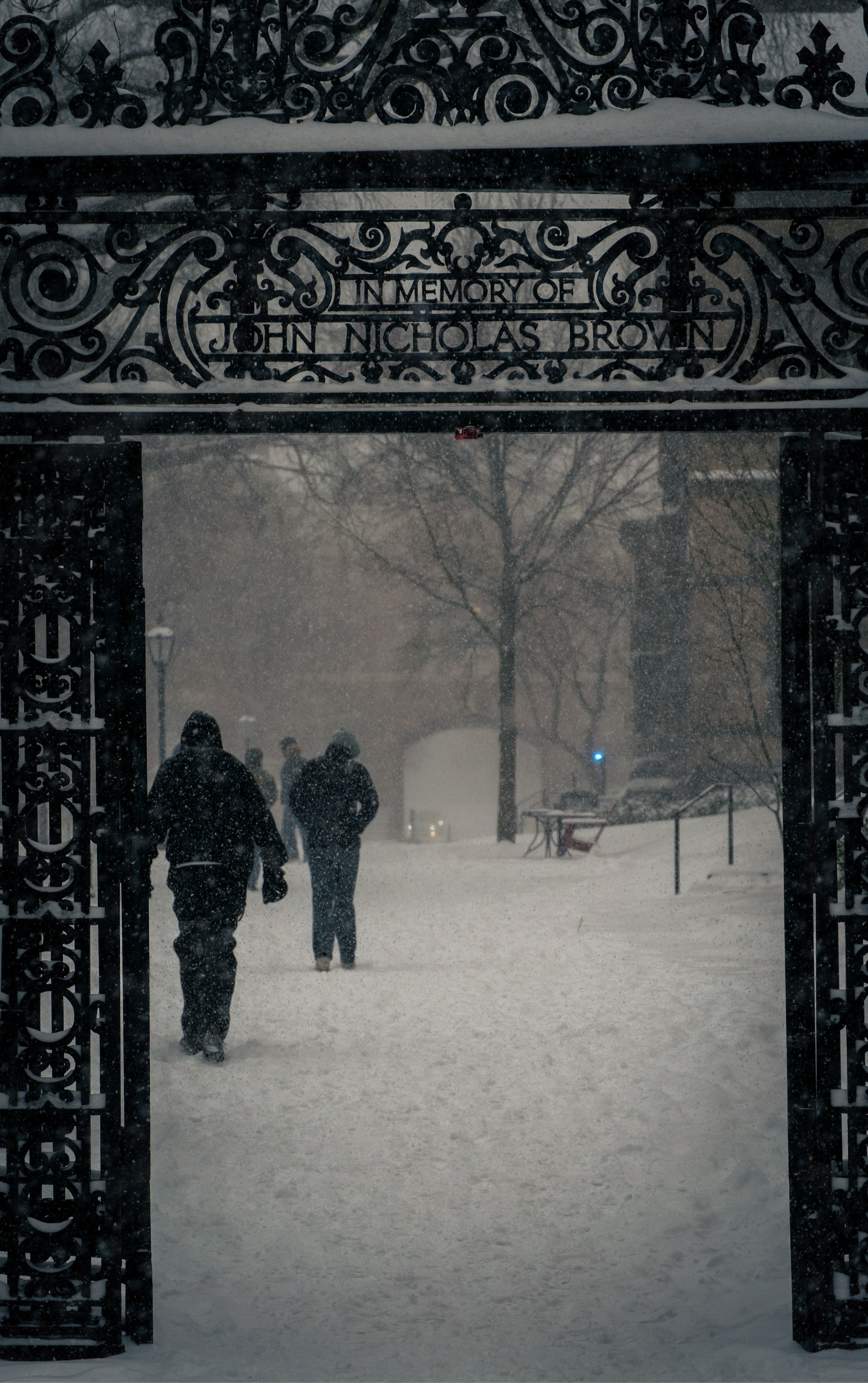 Photo of John Nicholas Brown black-iron gates opened up to students walking on the Main Green. 