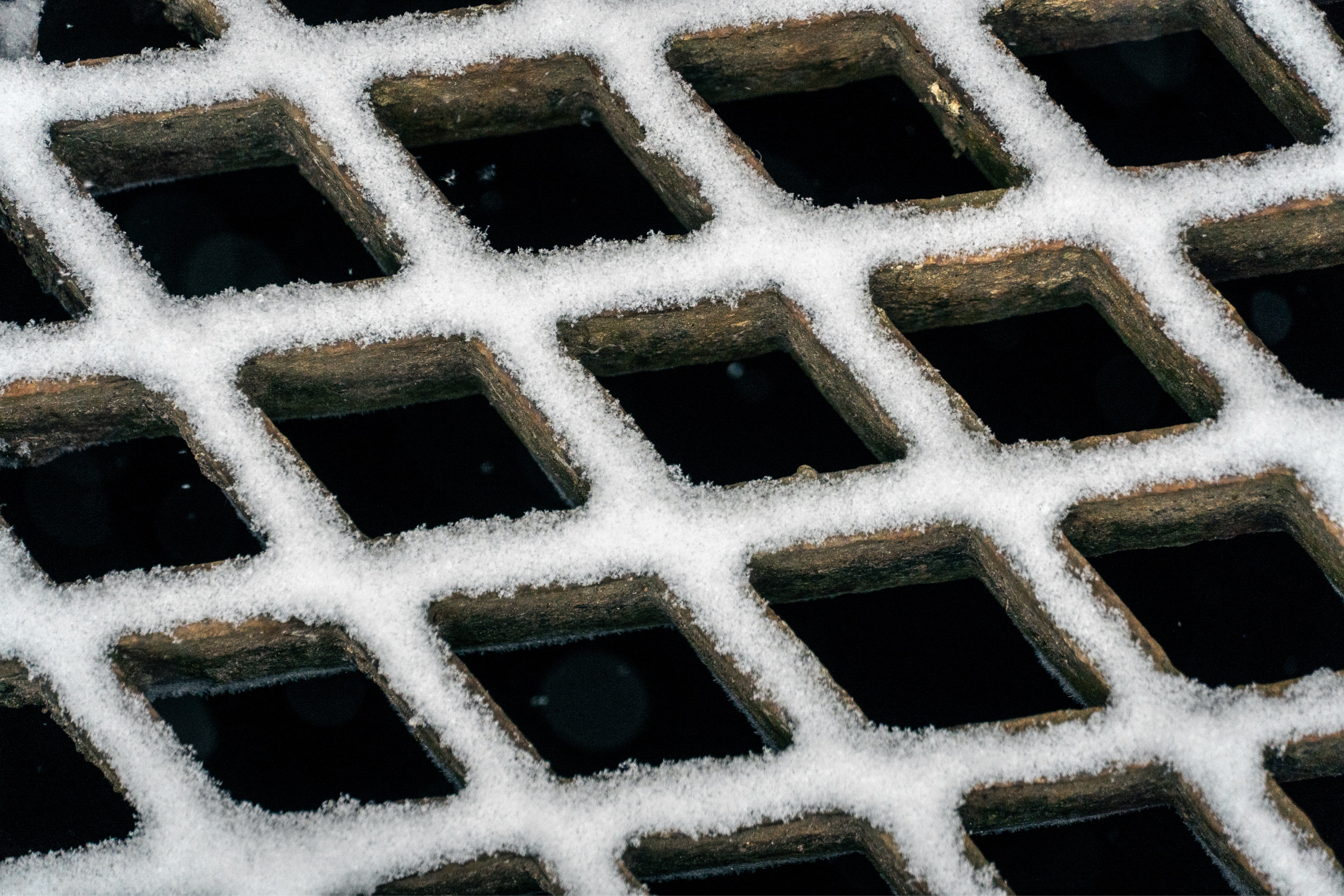 Photo of a snow-covered grate.