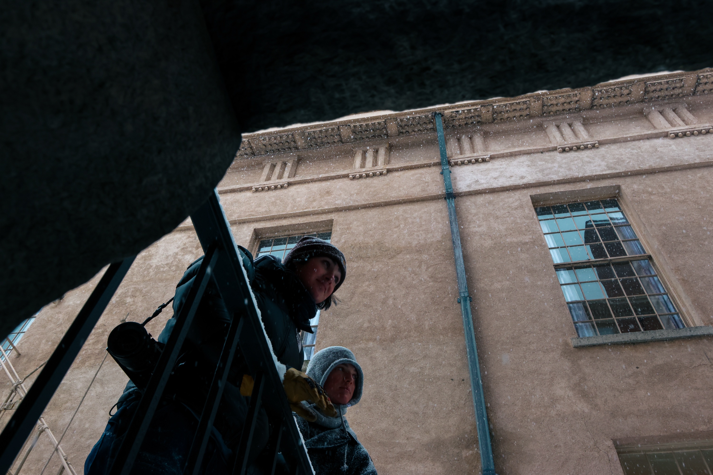 Photo of students leaning over railing coated in snow.