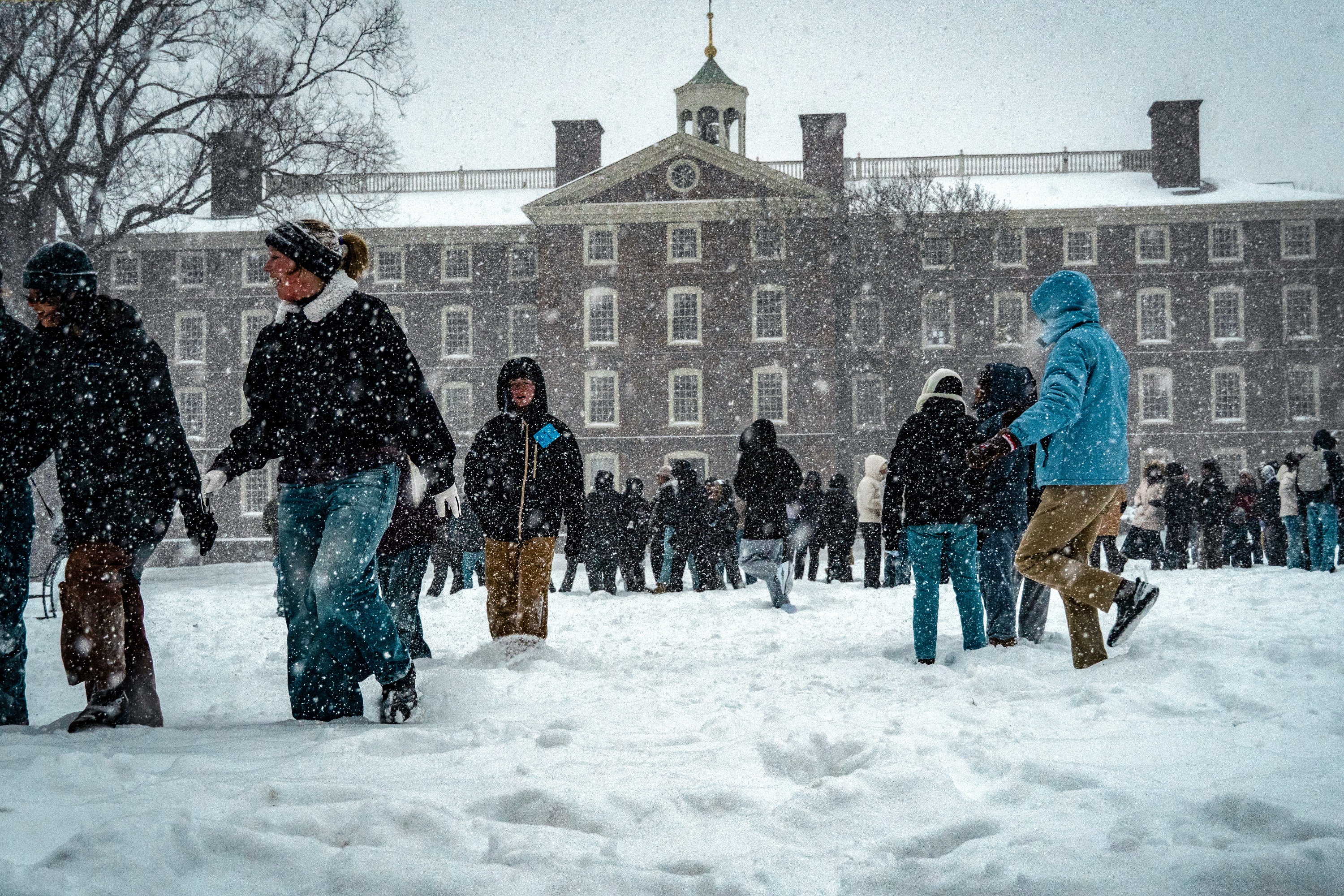 Photo of students walking on the Main Green as snow falls.