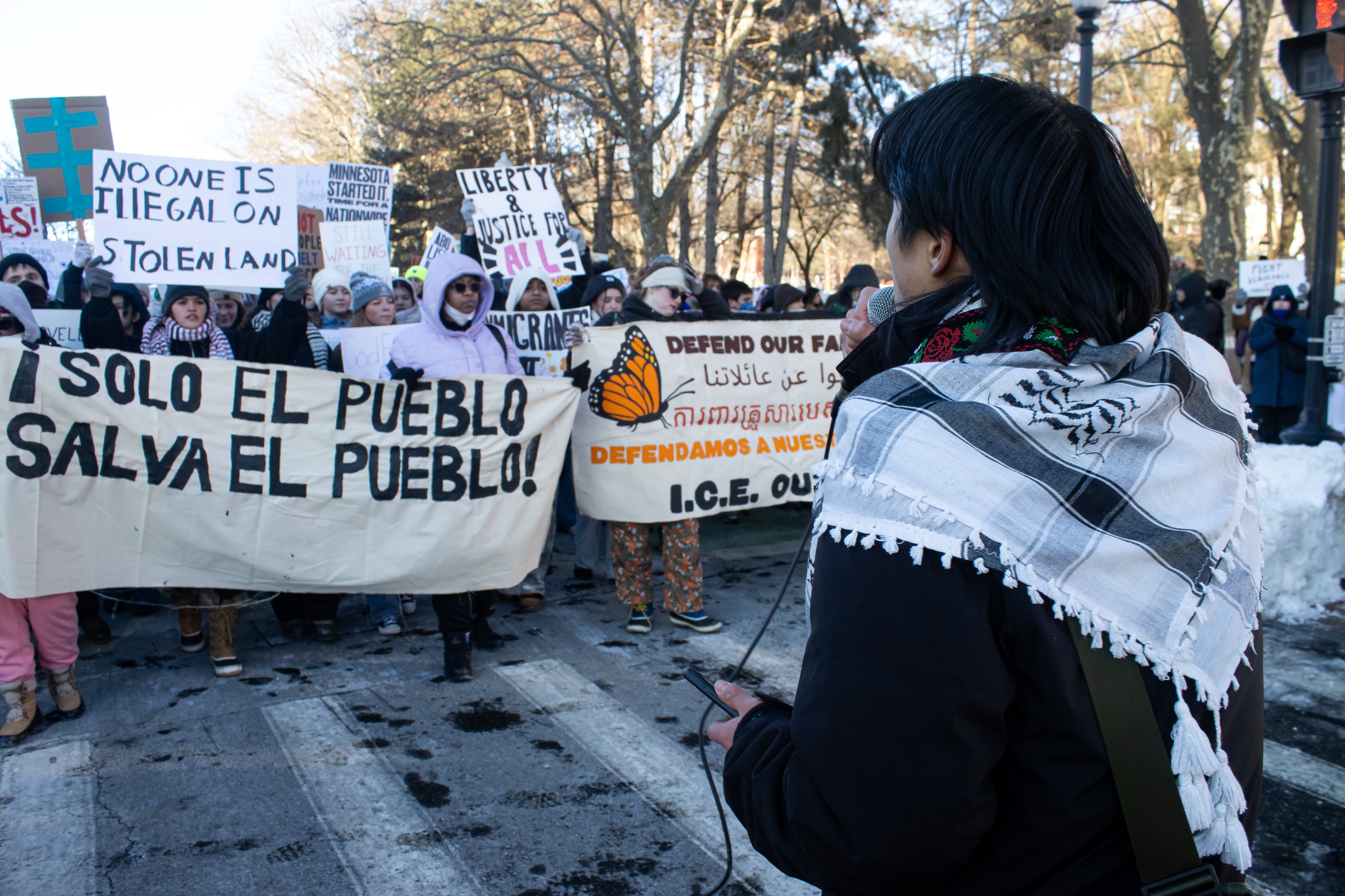 A line of protestors holding various signs. Many protestors wear surgical masks. Sign says “SOLO EL PUEBLO / SALVA EL PUEBLO.”